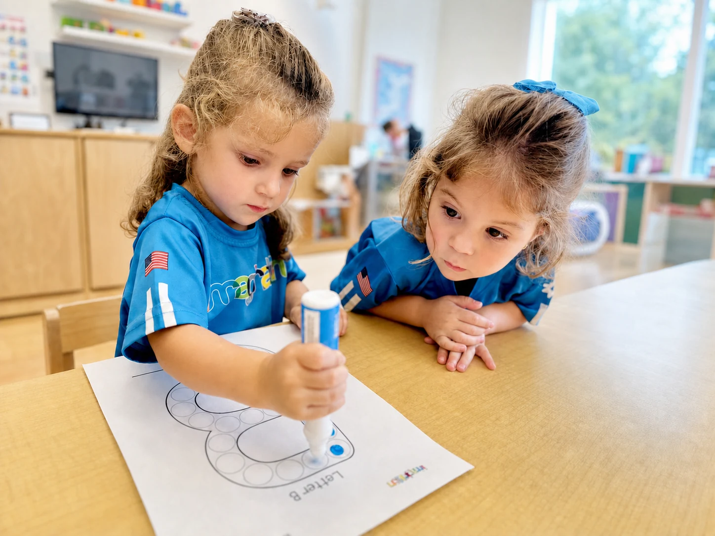 Two children drawing together at a classroom table