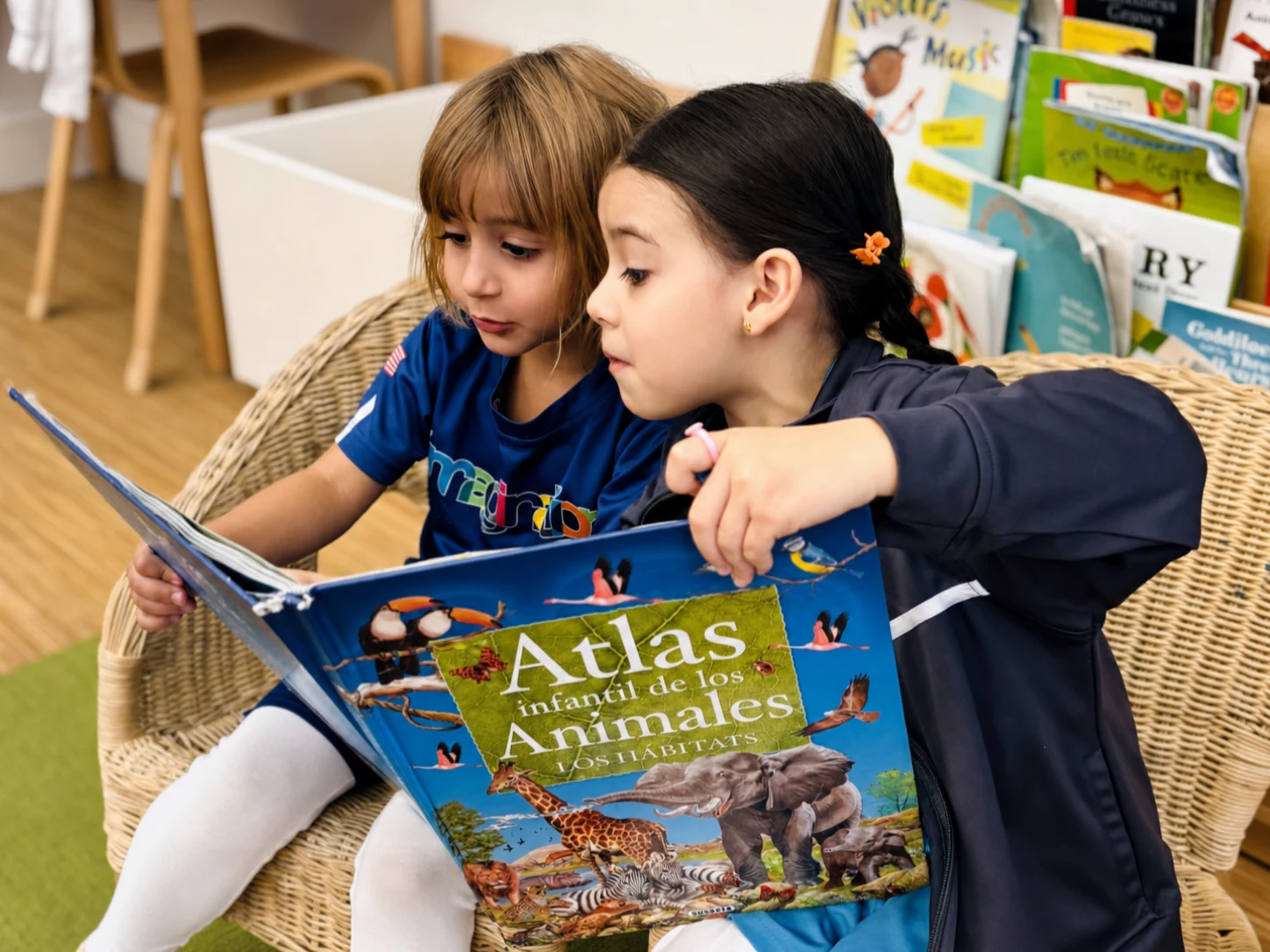 A child and facilitator exploring an animal atlas together